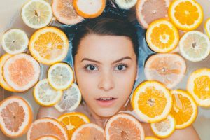 womans-face-surrounded-by-citrus-fruit